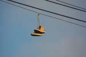 Close up of old sneakers hanging on a powerline in the evening glow